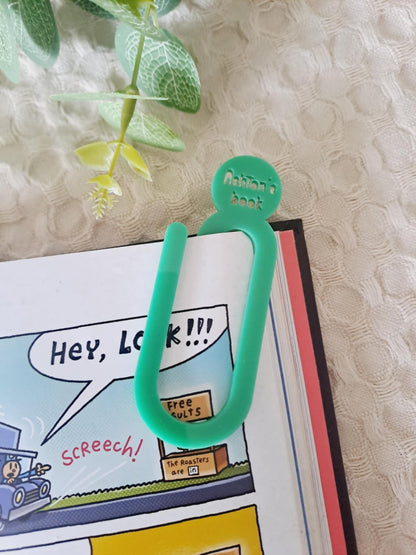 Green clip on a comic book with a plant in the background