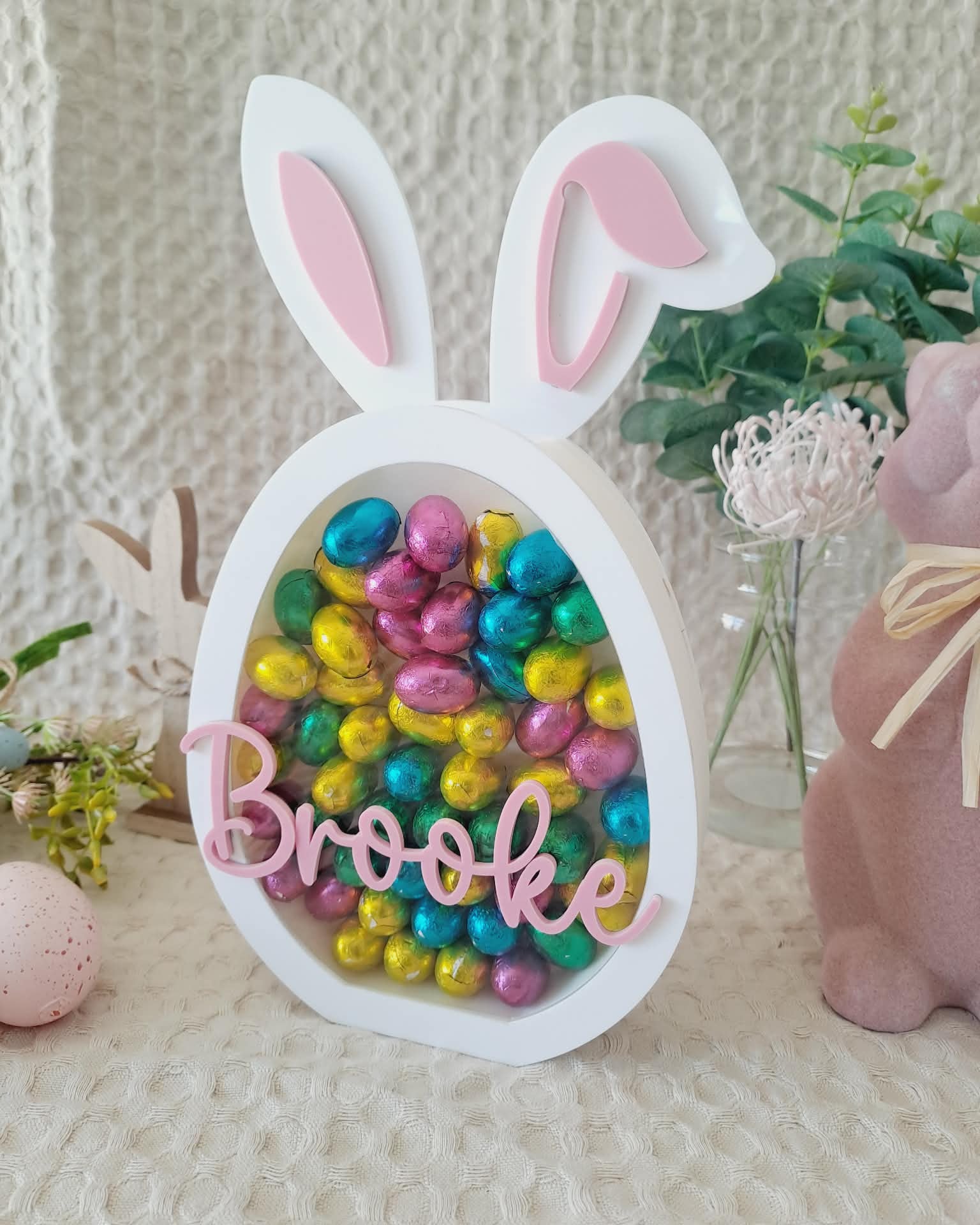 Decorative Easter egg with bunny ears and colorful candies, featuring the name 'Brooke'.